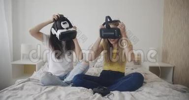 两个可爱的女孩在卧室里玩虚拟现实游戏。 虚拟现实，米勒，娱乐，爱好概念。 拍摄于红色。 12位