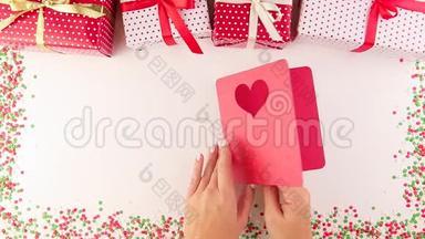 女人的手打开一张手工制作的圣诞贺卡。 新年礼盒。