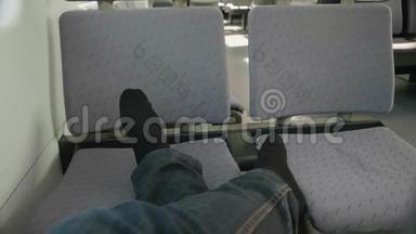 男人穿黑色袜子`腿的景色。 乘客在火车上靠椅子休息。 在旅<strong>途中</strong>休息。