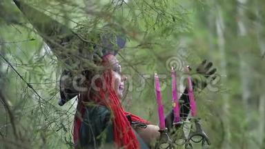 一个红头发，黑帽子，黑斗篷的年轻女巫在森林里从事魔法..