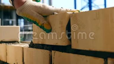 砖匠在一个建筑工地做砌砖工作。 一个砖匠在一个工地上工作，用铲子。