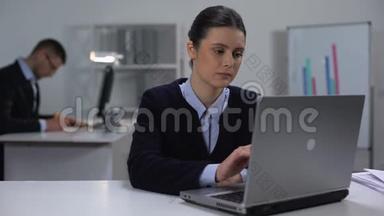 女经理在大公司上班的时候，在笔记本电脑上打字，前微笑