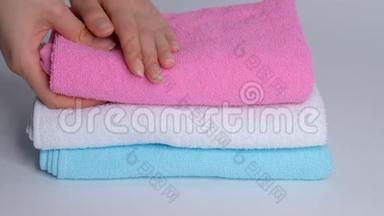 双手特写，把一叠新的浴巾放在<strong>床单</strong>上。 客房服务员清洁酒店客房