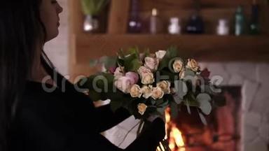 布鲁内特女花艺艺术家拿着美丽的玫瑰花束，郁金香在粉彩在车间。 集合