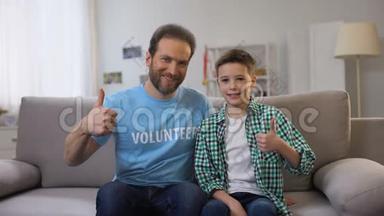 微笑的中年志愿者和小学生用大拇指对着镜头，广告