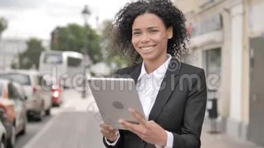 非洲女商人在桌上的在线视频聊天，站在户外的道路上