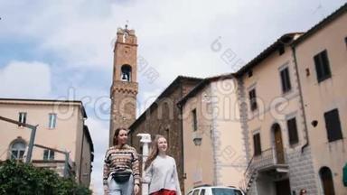 两个年轻的女人在镇上走来走去，远远地走到镜头前