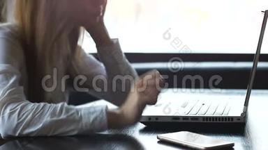 女人在手提电脑上工作，紧张地握紧拳头，担心项目