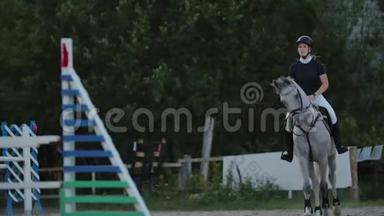 骑马的年轻女子在障碍物上跳跃。 慢动作。 比赛前训练马匹。 赛马。 马马马马