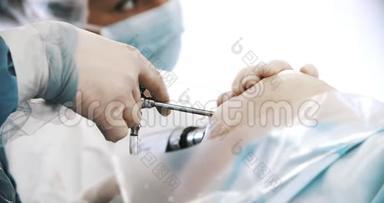 手术期间，外科医生团队用外科腹腔镜器械在膝盖上进行手术。 医学、外科