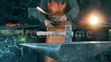 在<strong>锻造</strong>厂工作时，人们用锤子敲打一把热刀。