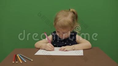 女孩在桌子边<strong>画画</strong>。 快乐的三岁女孩。 <strong>可爱</strong>的女孩微笑。 棕色的眼睛。 一个漂亮的小孩，3-4岁的女孩