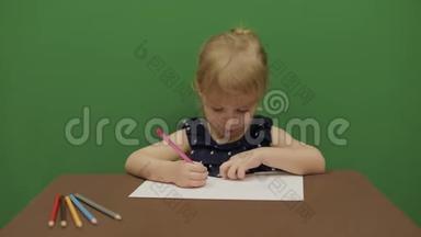 女孩在桌子边<strong>画画</strong>。 快乐的三岁女孩。 <strong>可爱</strong>的女孩微笑。 棕色的眼睛。 一个漂亮的小孩，3-4岁的女孩