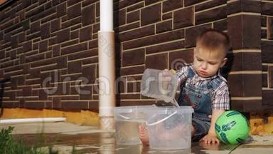 一个短发男孩从塑料桶里倒水