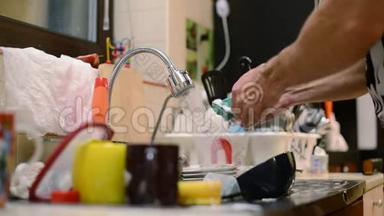 一个人洗碗，旁边是一大堆脏盘子。 双手特写，没有脸