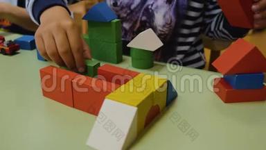 孩子们`手在桌子上收集明亮的木块特写。 逻辑思维。 学前儿童的发展