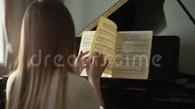 女钢琴演奏家，双手<strong>翻动</strong>音符，动作缓慢