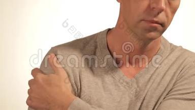 男人<strong>按摩</strong>他疼痛的<strong>肩膀</strong>，试图减轻疼痛的白色背景。 健康问题