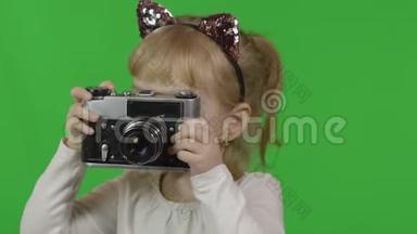 穿着猫头巾的女孩在旧的复古相机上拍照。 色度键