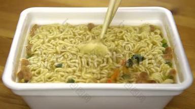 方便面和中国筷子混合在一起。 在一个特殊的塑料板上酿造黄色拉面