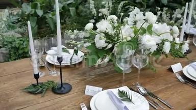 美丽的装饰，一张古老的木制桌子，用于一个乡村风格的婚礼晚会，花束和蜡烛