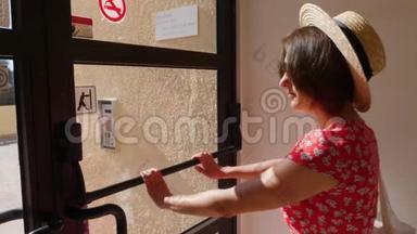 年轻女子穿着红色连衣裙和帽子打开后门。 后门从里面打开