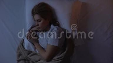 女人在睡梦中因强烈的偏<strong>头痛</strong>、噩梦、神经崩溃而哭泣