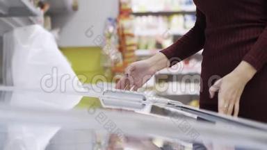 女人打开冰箱，在超市里寻找冷冻食品并把它关上