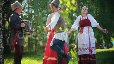 穿着俄罗斯<strong>传统</strong>服装的人们<strong>手</strong>牵<strong>手</strong>在球场上跳舞，其中一人演奏<strong>手</strong>风琴音乐