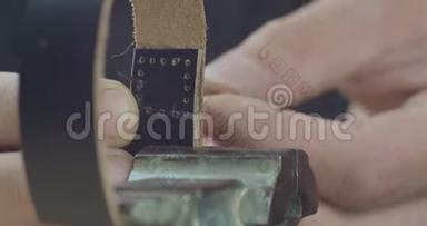 男用手特写黑色皮革手工缝制带针，制作工艺精品。电影院4k视频。