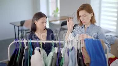 一个女人在房间里把衣服挂在衣架上，她的女朋友正在用滑稽的脸<strong>切线</strong>
