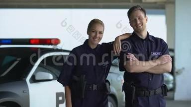 两名巡逻队员微笑着对着停车场的摄像头，准备执勤