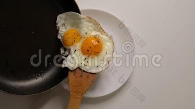 用香料<strong>煎鸡蛋</strong>是从盘子里的<strong>煎</strong>锅里放出来的。 俯视特写。 慢动作视频