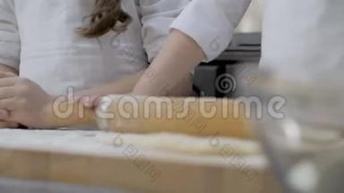 小女孩`手在木桌上<strong>擀面皮</strong>做披萨，特写