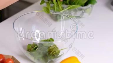 厨师把切碎的菠菜从木板上倒入玻璃碗里，做蔬菜沙拉，用
