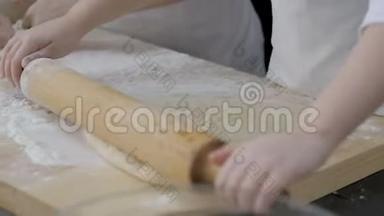 小女孩`手在木桌上擀面皮做披萨，特写