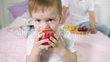 小男孩正在<strong>父母</strong>`卧室里吃苹果。 他的<strong>父母</strong>坐在床上。