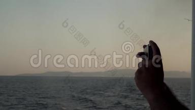 男子用电话拍摄帆船、<strong>海洋</strong>、太阳、蓝色、<strong>海洋</strong>、地平线和<strong>海洋</strong>的照片。 旅费