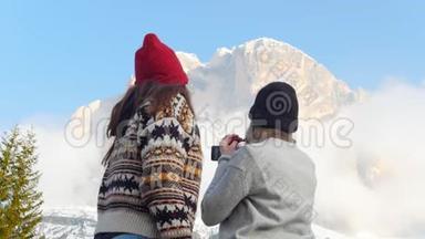 两个年轻女子站在一片阴云密布的群山背景上，自拍