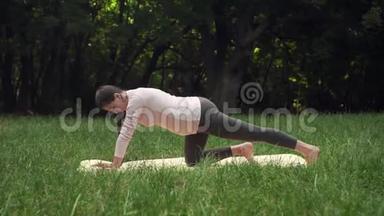 孕妇在公园的地毯上做瑜伽，单膝站立，做<strong>小腿肌肉</strong>伸展。