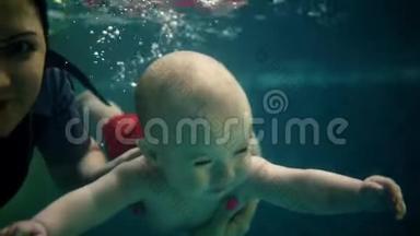 幸福的家庭-母亲带着小儿子潜<strong>入水</strong>下，在<strong>游泳</strong>池里玩得很开心。 健康的生活方式，积极的父母
