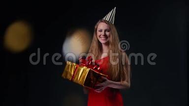 戴着<strong>节日</strong>帽子的可爱的年轻女人拿着一个带有礼物的<strong>节日</strong>盒子