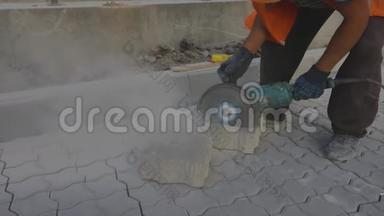 一名工人正在用<strong>磨床</strong>切割一块石瓦，一名工人正在用<strong>磨床</strong>切割一块砖