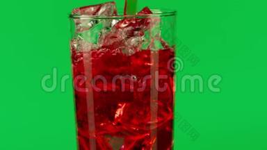 将红色饮料倒入杯中，在绿色<strong>背景</strong>下加入<strong>冰块</strong>，特写慢动作拍摄红色