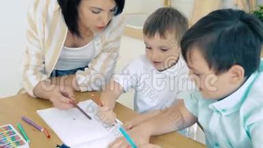 妈妈帮助两个儿子在相册里画记号。 学前教育