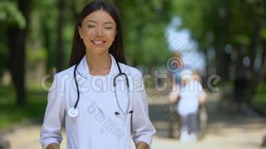 微笑女医生在康复中心附近的公园里看镜头