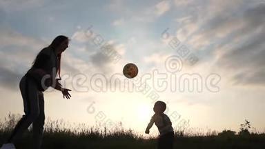 2岁的男孩在日落时分像排球运动员一样缓慢地打球