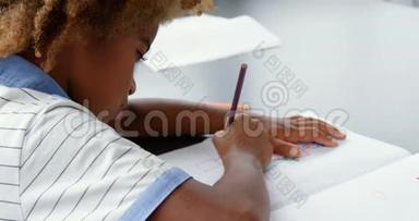 美国非洲人的侧视图在教室4k的笔记本上绘制草图