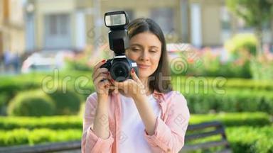 女摄影师在公园用相机拍照，为初学者上课
