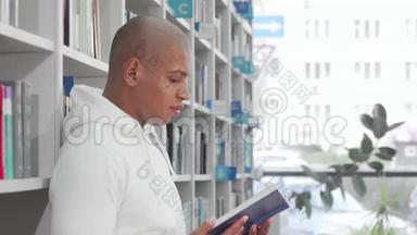 英俊的非洲男<strong>人</strong>在<strong>图书馆看书</strong>时对着镜头微笑